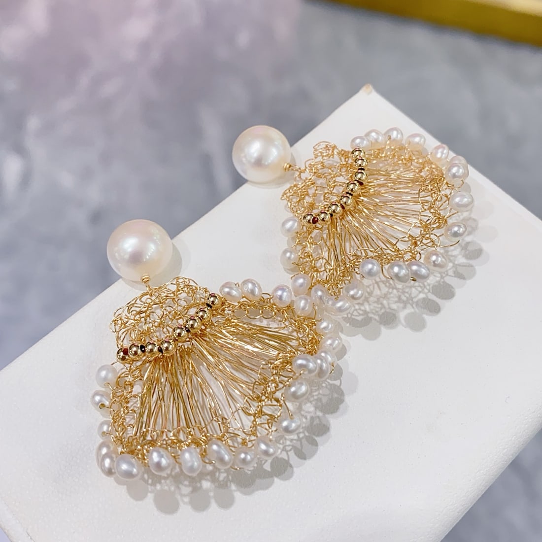 Natural Freshwater Pearl Earrings: Title: Natural Freshwater Pearl Earrings Description: These earrings feature material with natural freshwater pearls, showcasing a rich golden luster and cool white hue. The large diameter and minimal