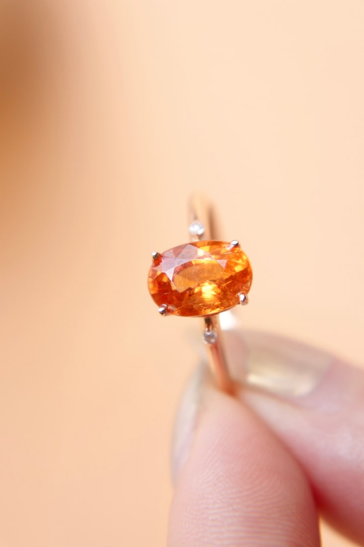 18K Gold Garnet Ring: Title: 18K Gold Garnet Ring Description: This 18K gold ring features a natural garnet with a main stone weighing 2.61 carats. The stone is a rich gold with cool white crystals, showcasing a texture