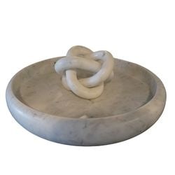 Carved White Marble Knot Sculpture in Marble Tray: This contemporary decorative piece features a sculptural knot crafted from polished white marble, resting within a circular, shallow marble tray. The marble displays natural veining, adding a subtle