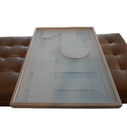 Contemporary Geometric Layered Paper Art in Light Wood Frame - Four Hands: This contemporary artwork features a captivating geometric composition created with multiple layers of cut paper, presenting a three-dimensional effect. The piece is housed in a sleek, light-toned woo