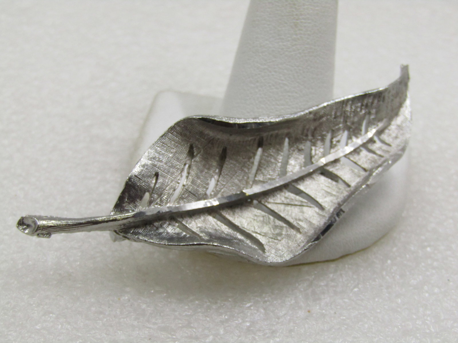 Vintage Silver Tone Leaf Brooch, Signed J.S. 3": Vintage Silver Tone Leaf Brooch, Signed J.S. 3" tall and 1-1/8" wide. Curved with cut-out veining and smooth stem. Age is appx. 1960's-1970's. (W.11321.4 SS6773 AZ LEB* LD 11321.4 LD 5/22/22).
