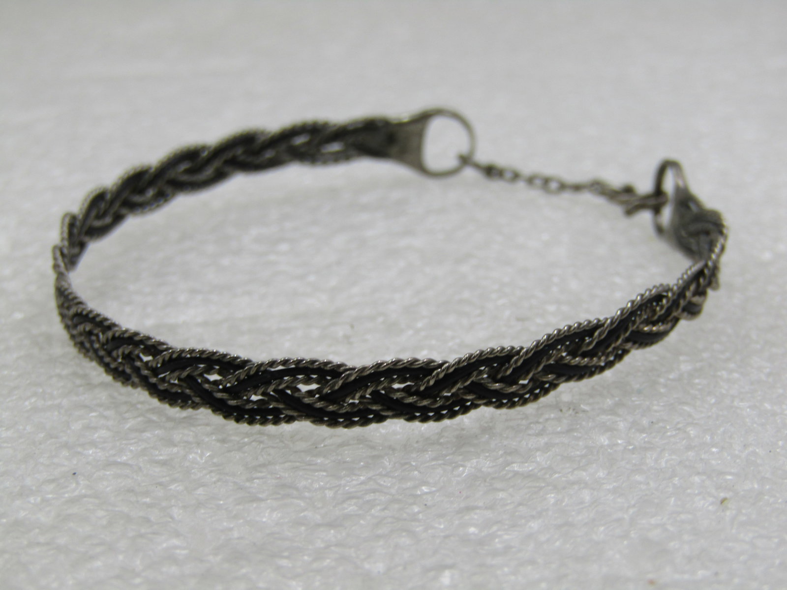 Vintage Silver Plated Braided Cuff Bracelet, with Hook Clasp.: Vintage Silver Plated Braided Cuff Bracelet, with Hook Clasp.5mm wide braided cuff style bracelet with two loops on the back ends with a chain and hook clasp. 7.25" when hooked closed. It is not