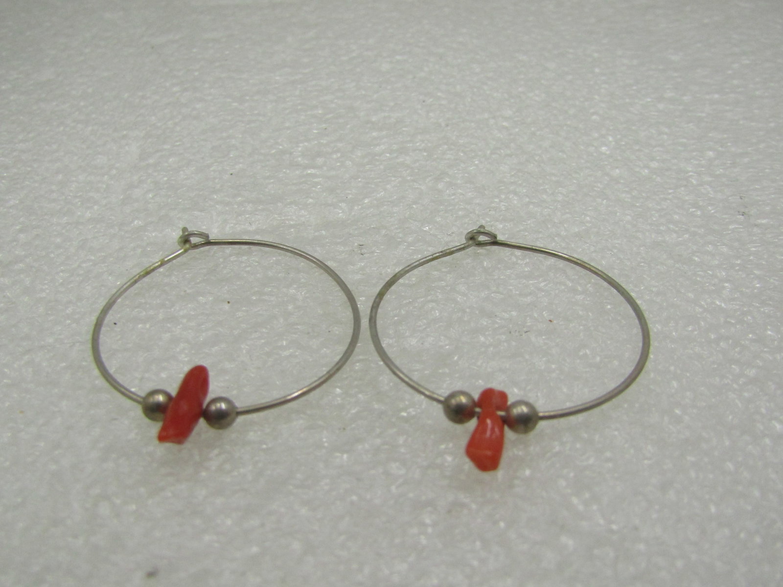 Vintage Sterling Southwestern Coral Hoop Earrings, Pierced: Vintage Sterling Southwestern Coral Hoop Earrings, Pierced1.25" lround hoops with a built-in ring that the post slips into to lock in place. two 3mm round silver beads in each earrings that flank an a