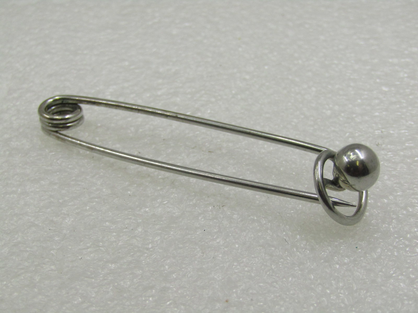 Vintage Skirt/Kilt Brooch, Silver Tone Bead Accent 3": Vintage Skirt/Kilt Brooch, Silver Tone Bead Accent 3" tall and appx. 5/8" wide. Safety pin design with a hook clasp and 8mm bead at the clasp end. Not signed by the maker Very good condition. Post