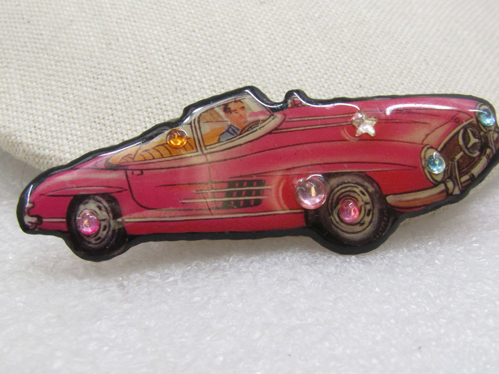 Vintage DFTD Signed Mercedes Convertible Brooch: Vintage DFTD Signed Mercedes Convertible Brooch, 3" by 1". Pink convertible driven by a man embelisshed with acryliic rhinestones - as headlights, wheel centers and more, round and star too. DFTD has