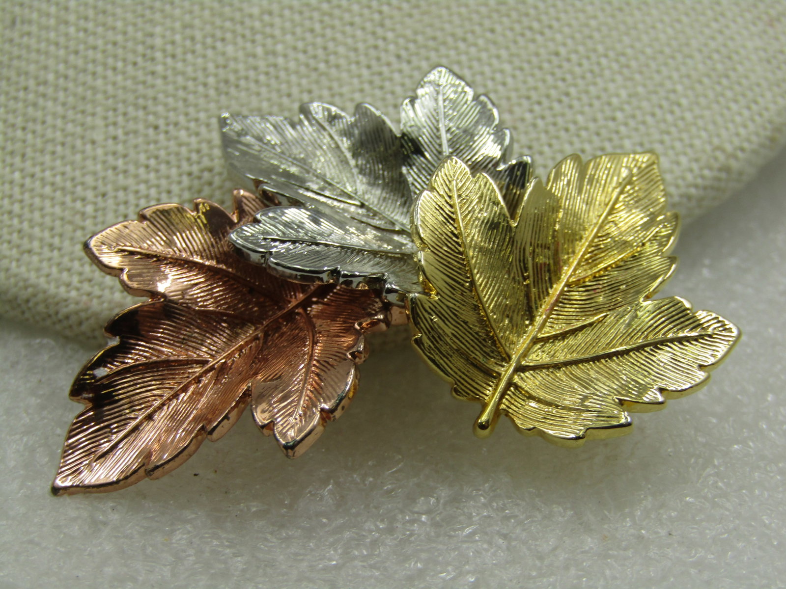 Vintage Tri Color Stacked Leaf Brooch, 1960s-1970's: Vintage Tri Color Stacked Leaf Brooch, 1960s-1970's. Three maple please overlapping each other in yellow gold tone, silver tone, and copper tone. 2" tall and appx. 1.25" wide. Nicely made and in very 