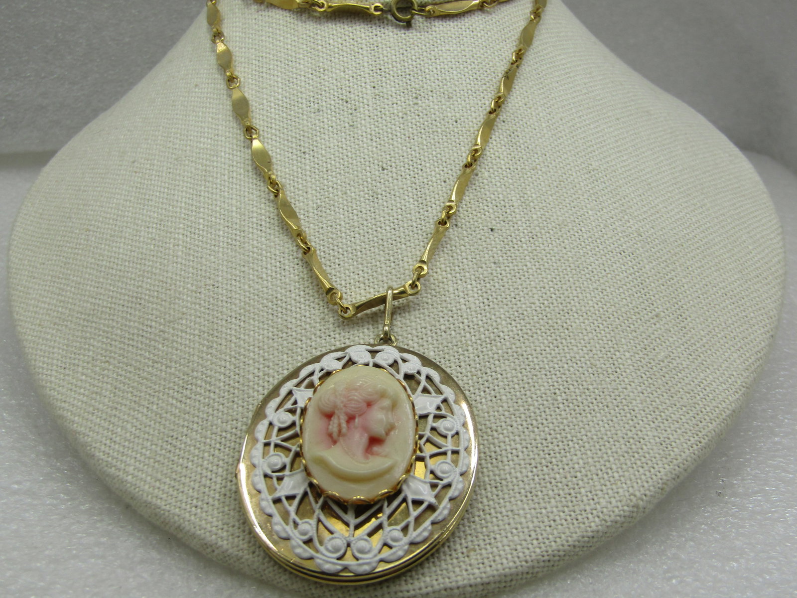 Vintage Cameo Lace Locket Necklace, 24"m 1960's-1970's: Vintage Cameo Lace Locket Necklace, 24"m 1960's-1970's. The cameo locket has a white lace background enameled in white with an overlay of an oval plastic molded cameo in a pale tan color with pink was