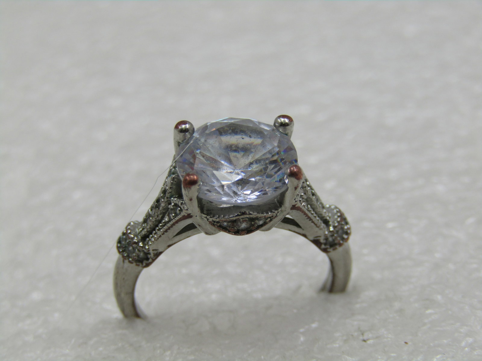 Vintage Silver Plated Clear Stone Engagement Ring, Sz. 7,: Vintage Silver Plated Clear Stone Engagement Ring, Sz. 7, The round stone is appx. 9.5mm round. Very nice desig with milgrain aceents. This is a costume ring. It is marked .925 but it s a thinly