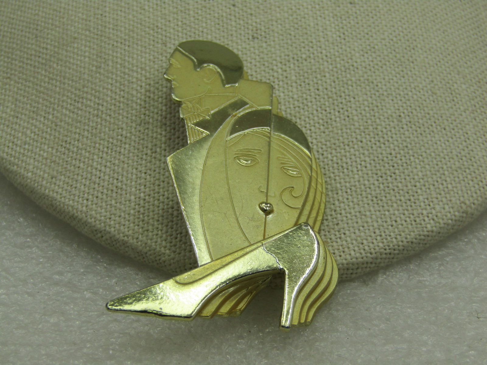 Vintage Art Deco Themed Brooch, Signed CAJC, Man, Woman, Shoe: Vintage Art Deco Themed Brooch, Signed CAJC, Man, Woman, Shoe. This has a stacked design in both smooth and shiny finish and satiny finish gold tone metal. A stacked design with an overlapping