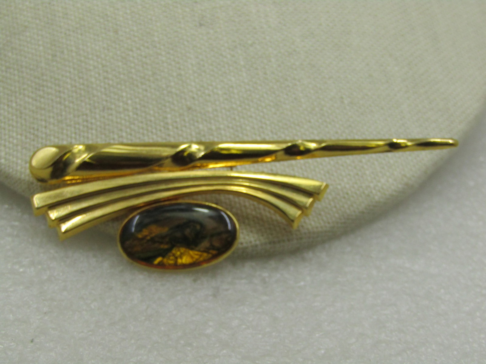Vintage Gold Tone Brooch, Foiled Amber Stone, 3.25": Vintage Gold Tone Brooch, Foiled Amber Stone, 3.25" tall and 1" wide. It has a bezel-set 1" amber colored golden foiled cabochon set off on one side. The cabochon has a wedge of bright foil and the
