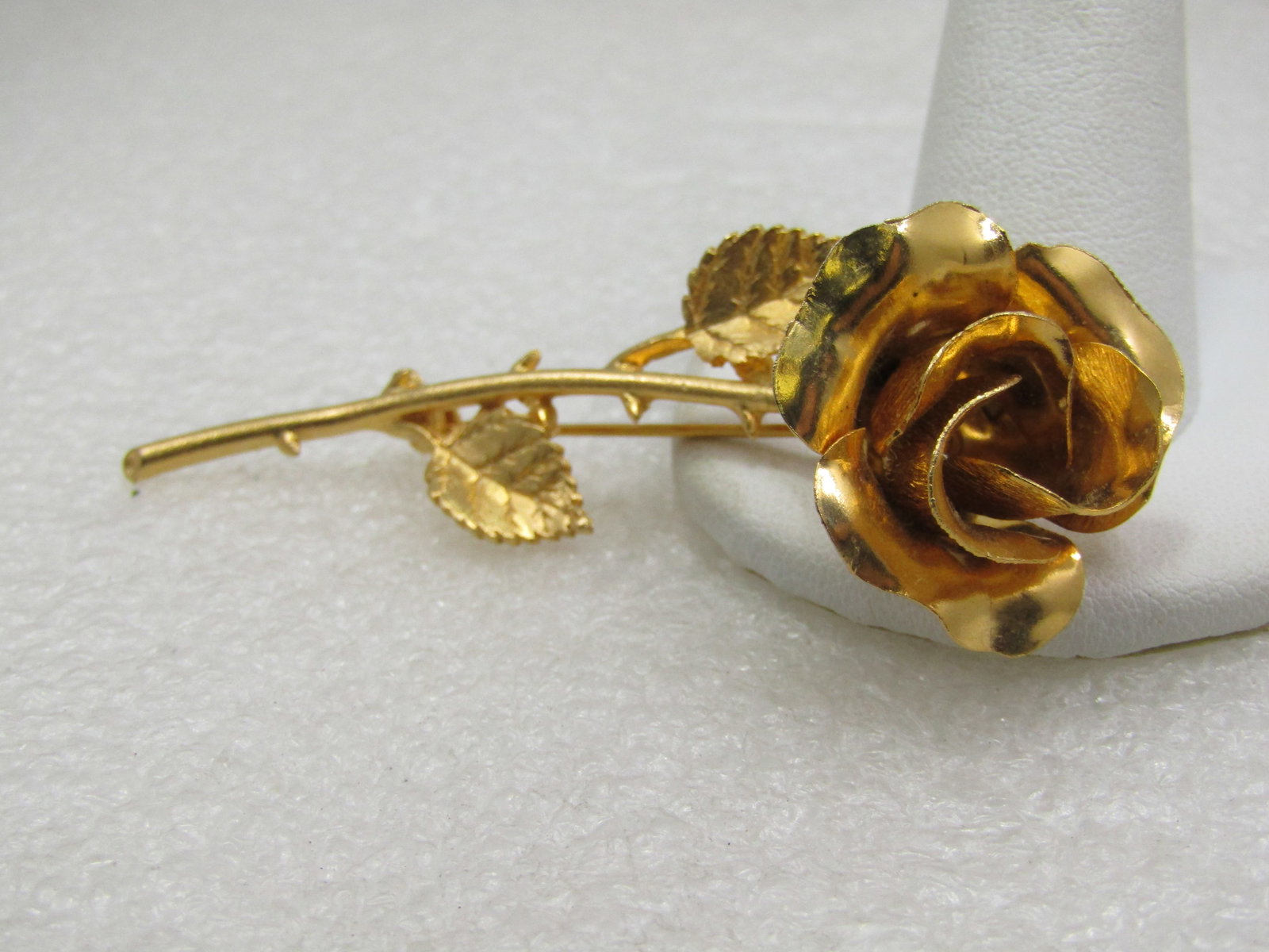 Vintage Gold Tone Long Stem Rose Brooch, 3": Vintage Gold Tone Long Stem Rose Brooch, 3" tall and 1" wide at the 3-d rose blossom. , 1960's-1970's. Textured adn smoth finish, with thorns on the stem. Not signed by the maker. Very good