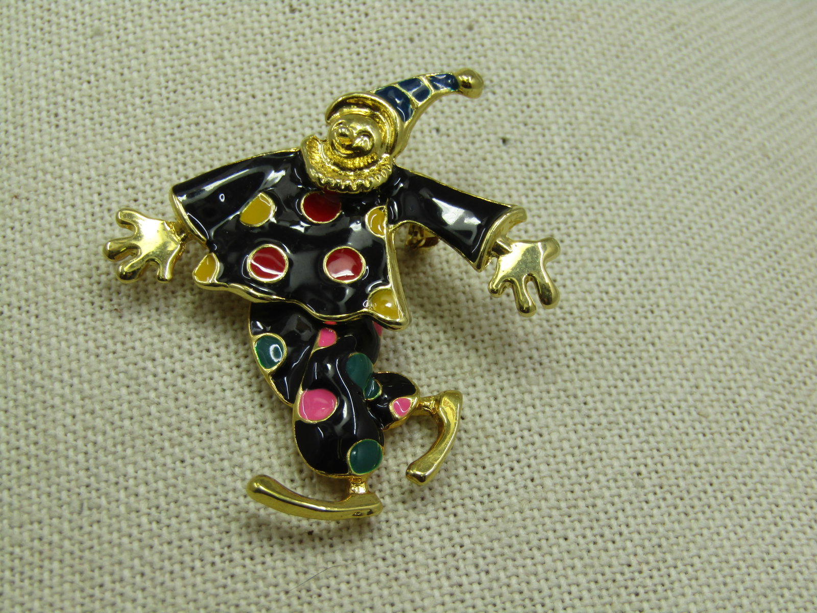 Vintage Enameled Articulated Clown Brooch, 2": intage Enameled Articulated Clown Brooch, 2" tall and 1.75" wide at the arms. Gold tone and blacked enameled clothing with red, yellow, green, pink enameled spots and a black hat with gold ball on top