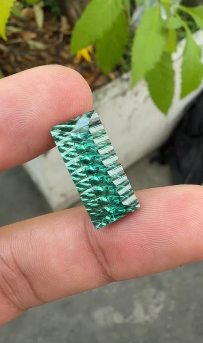 12.86 Carat Fancy Long Emerald Cut Green Tourmaline Gemstone, Waves Pattern Cut: Title: 12.86 Carat Fancy Long Emerald Cut Green Tourmaline Gemstone, Waves Pattern Cut Gemology: • Weight : 12.86 Carat • Dimension : 20.45*9.40*7.95 MM • Color: Green • Clarit