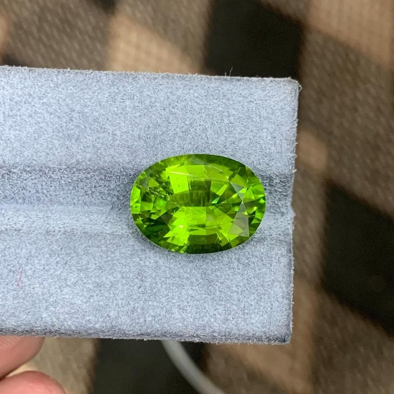 Apple Green Peridot Gemstone: 9.20 Carat Faceted Oval Cut: Title:Apple Green Peridot Gemstone: 9.20 Carat Faceted Oval Cut Description: A dazzling Green Peridot Loose Gemstone, boasting a sparkling green hue in a faceted Oval cut. This 9.20 carat beauty is