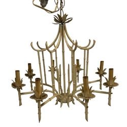Chic Faux Bamboo Chandelier in Distressed Cream Finish: This elegant faux bamboo chandelier features a distressed cream finish, giving it a charming, aged appearance. The intricate design mimics natural bamboo stalks, characteristic of Hollywood Regency
