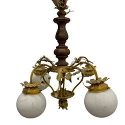 Arts & Crafts Style Gilt Metal and Wood Chandelier: This chandelier features a turned wooden central column, complemented by three scrolling gilt metal arms adorned with decorative leaves. Each arm supports a spherical, marbled glass shade. The design