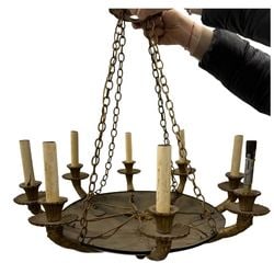 Gilt Bronze and Patinated Metal Eight-Light Chandelier: This eight-light chandelier features a central patinated metal dish from which eight gilt bronze arms emerge, each terminating in a bobeche and a faux candle sleeve. The arms are adorned with ornate