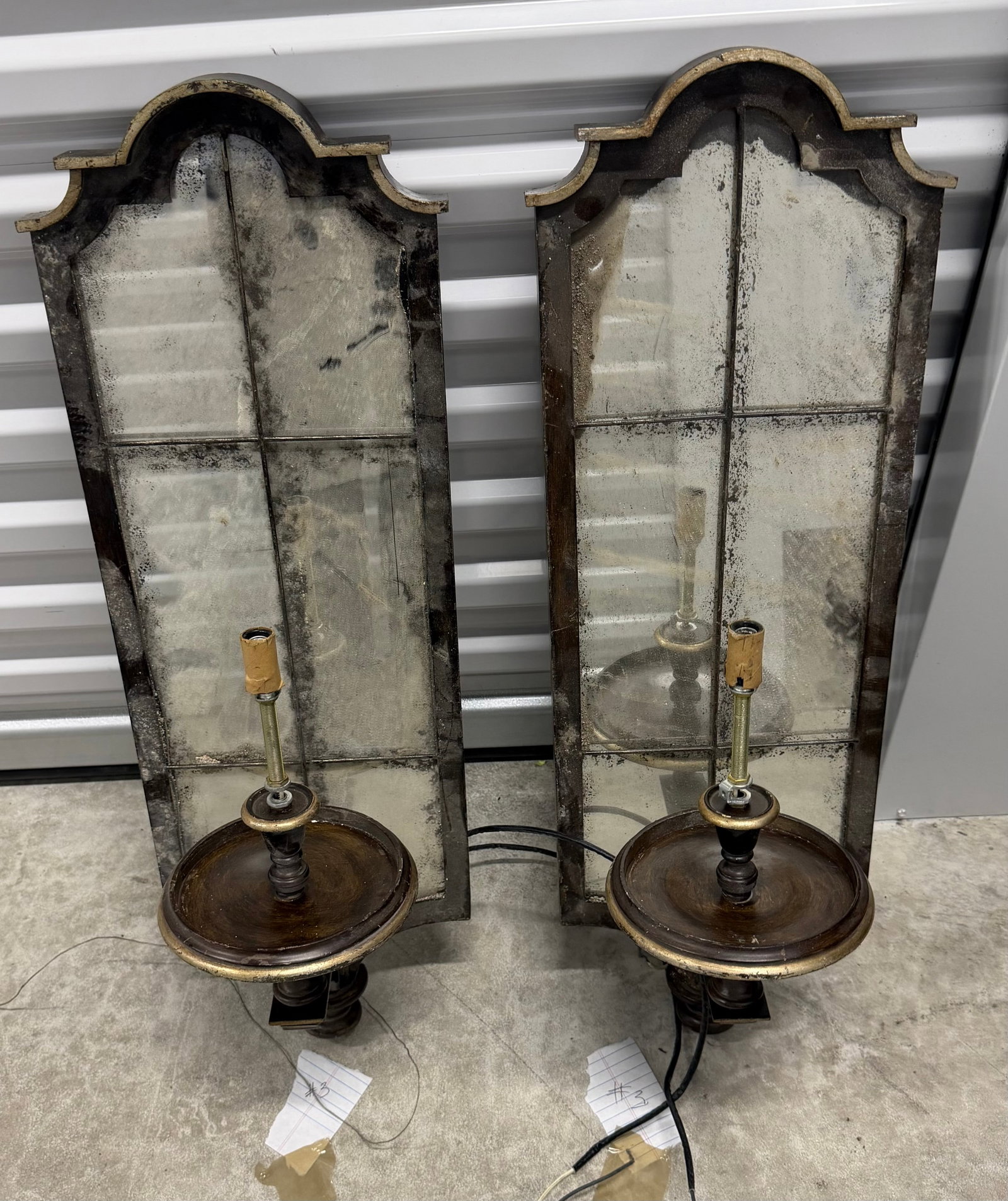 Pair of Ornate Giltwood and Antiqued Mirror Sconces #4: A striking pair of giltwood and antiqued mirror wall sconces, each featuring a shaped, arched top and a segmented mirror panel designed to mimic a window pane. The mirrors exhibit purposeful