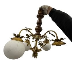 Vintage Brass and Wood Five-Light Chandelier with Frosted Glass Shades: This vintage chandelier features a central turned wood column supporting five brass arms adorned with delicate floral and leaf motifs. Each arm terminates in a frosted white glass globe shade,