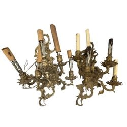 Pair of Ornate Gilt Bronze Rococo Style Wall Sconces: A pair of ornate gilt bronze wall sconces, likely dating to the early 20th century, executed in the Rococo style. Each sconce features a scrolling rocaille-form backplate with acanthus leaf motifs,