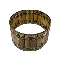 Arts & Crafts Style Stained Glass Lamp Shade: An attractive Arts & Crafts style drum-form lamp shade. The shade features leaded stained glass panels in warm amber and cream tones, accented with a band of emerald green geometric inserts. The