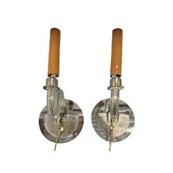 Pair of Mid-Century Modern Chrome and Crystal Sconces: A pair of mid-century modern sconces featuring a chrome finish backplate and a clear glass tubular arm. The light source appears to be a tube-shaped bulb with a warm amber or peach-colored casing,