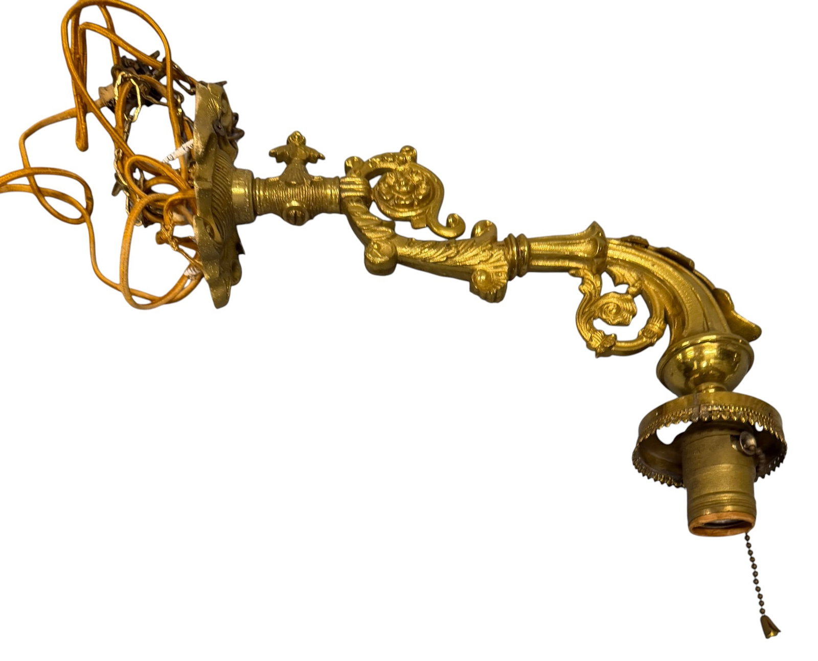 Ornate Brass Wall Sconce: An ornate brass wall sconce featuring a highly decorative arm with rococo-style scrollwork and acanthus leaf motifs. The backplate is similarly adorned with intricate floral and scroll designs. The