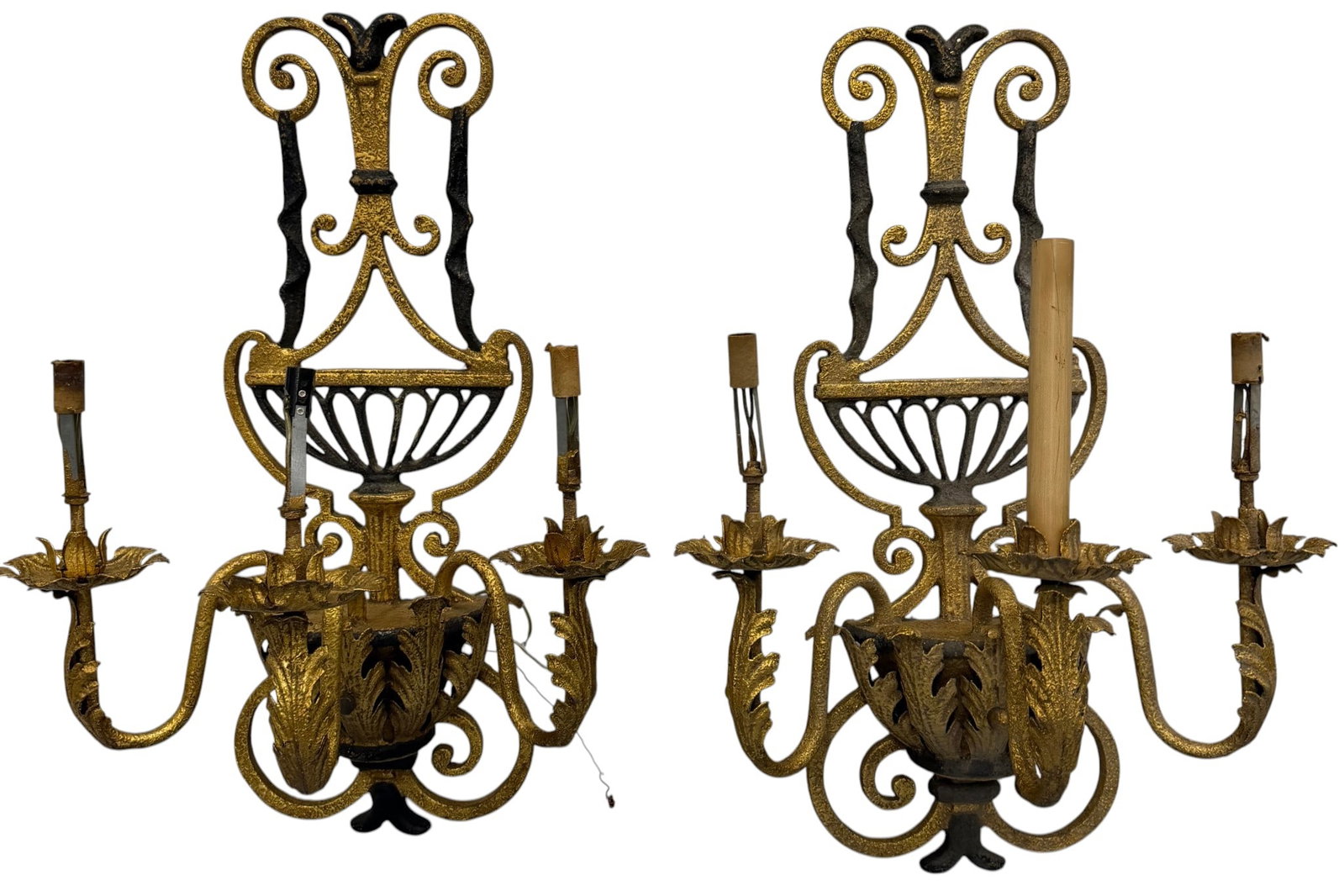 Pair of Gilt Wrought Iron Wall Sconces, Neoclassical Style: A striking pair of Neoclassical style gilt wrought iron wall sconces. Each sconce features an ornate scrolled backplate with a central decorative element and a basket-like lower section. Three