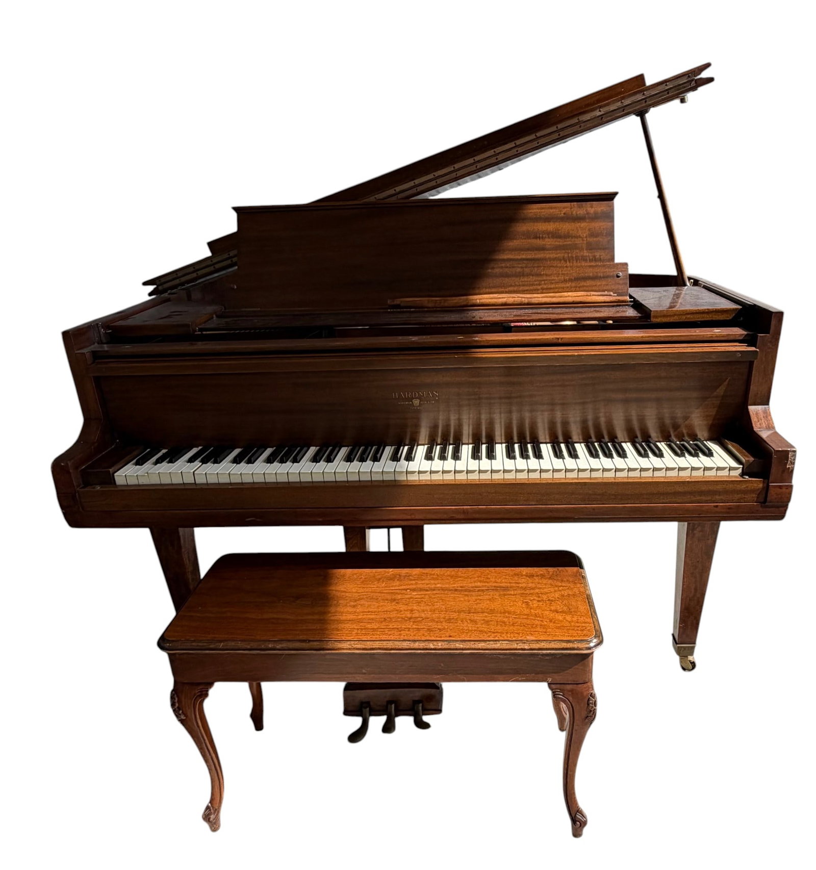 Hardman, Peck & Co. Grand Piano with Matching Bench: A handsome Hardman, Peck & Co. grand piano, model unknown, crafted from rich mahogany with a polished finish. The piano features a full 88-key keyboard with white and black keys. It includes a