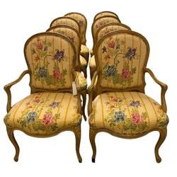 Set of Eight French Provincial Style Dining Chairs: A set of eight French Provincial style dining chairs, likely late 20th century. Each chair features a distressed cream-painted wooden frame with elegant carved details, including a shaped top rail