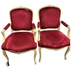 Pair of Louis XV Style Carved Wood and Red Upholstered Armchairs: A pair of Louis XV style armchairs, likely mid-20th century, featuring carved wooden frames with a distressed off-white painted finish. The chairs are upholstered in a rich red velvet or velour fabric
