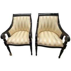 Pair of Regency Style Klismos Chairs: A handsome pair of Regency style klismos chairs, likely early to mid-20th century. Each chair features a black lacquered frame with scrolled arms and saber legs, characteristic of the Regency period. 