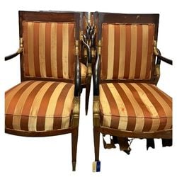 Set of Twelve Empire Style Armchairs: A commanding set of twelve Empire style armchairs, likely early to mid-20th century. Each chair features a rich, dark-stained wooden frame with classical details, including gilded carved accents on