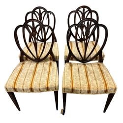 Set of Four Chippendale Style Carved Mahogany Dining Chairs: A set of four elegant Chippendale style dining chairs crafted from carved mahogany. Each chair features a distinctive heart-shaped openwork backsplat with delicate floral and foliate carving at the