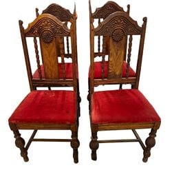 Set of Four Carved Oak Dining Chairs with Red Velvet Upholstery: A set of four late 19th or early 20th-century dining chairs, crafted from oak with intricate carving, likely in the Aesthetic Movement or Arts and Crafts style. Each chair features a tall back with a