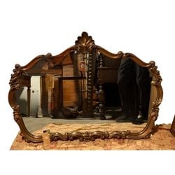 Ornate Rococo Style Giltwood Wall Mirror: An ornate Rococo-style wall mirror, likely from the mid-20th century, featuring a heavily carved giltwood frame. The frame displays classic Rococo motifs including C-scrolls, acanthus leaves, and a