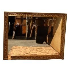Large Giltwood Framed Wall Mirror: This imposing wall mirror features a rectangular form with a thick, ornate giltwood frame. The frame is elaborately carved with rocaille, floral, and acanthus leaf motifs, indicative of the Rococo