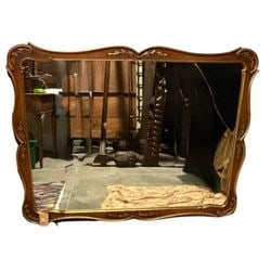 Giltwood Rococo Style Wall Mirror: An ornately carved giltwood wall mirror in the Rococo style, likely dating from the mid-20th century. The frame features a classic cartouche-shaped top with scrolling acanthus leaf details and floral