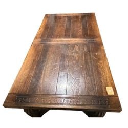 Carved Oak Refectory Dining Table: This impressive carved oak refectory dining table likely dates from the early to mid-20th century, crafted in a revivalist style reminiscent of 17th-century Jacobean or Baroque furniture. The table