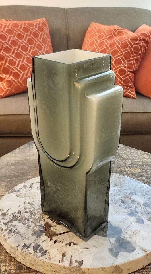 Stunning Vintage Deco-Inspired Smoky Gray Green Art Glass Vase. Heavy. 13h x 6w x 3d: This art deco vase is characterized by its distinctive smoky gray hue and stepped design, rendering it perfect for floral arrangements or as a wonderful standalone decorative accent.. Reserve: $150.00
