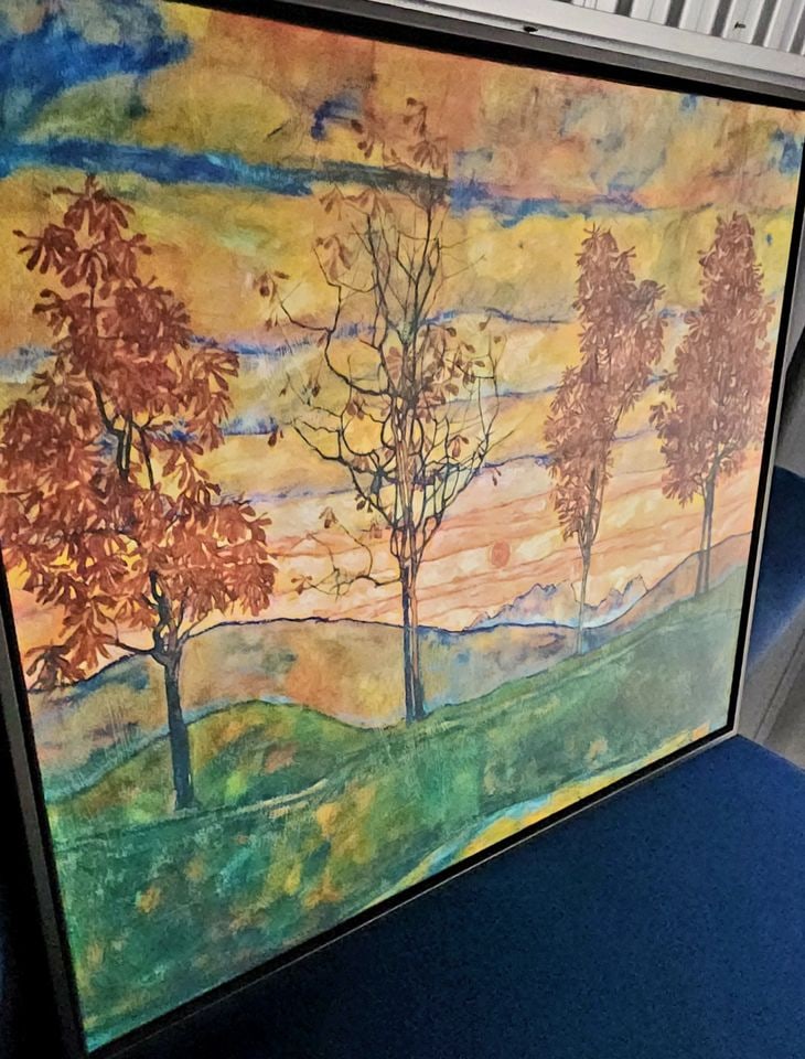 Vibrant Impressionist giclee print painting on canvas inspired by fauvist period 40 x 24 x 3"w frame: Colorful impressionist landscape painting is a giclee canvas print with a wide black floating frame. Piece features four stylized red trees against a vibrant sunset background with orange, yellow, and
