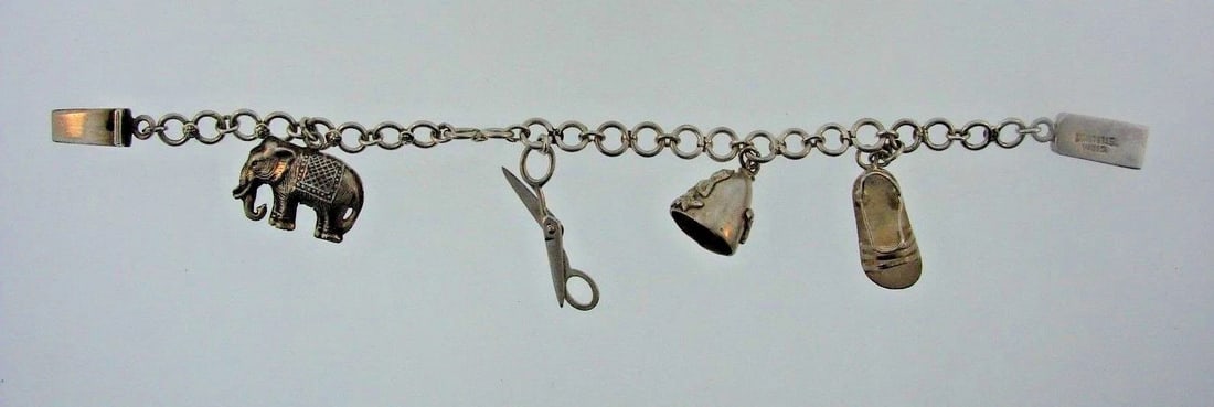 TIMELESS Sterling Silver Bracelet with Charms: Title: TIMELESS Sterling Silver Bracelet with Charms Description: DK Sterling Silver Bracelet with Charms · This is a must for any collector. · The weight is 11.5 grams. The length is 6 1/8 