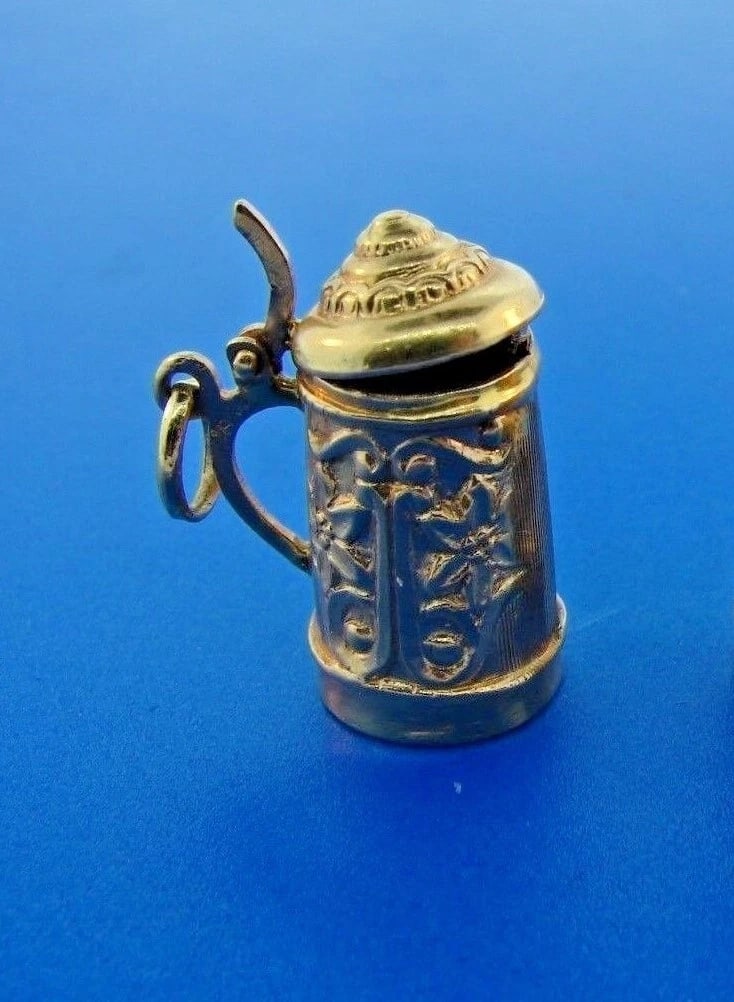 HOORAH Beer Stein 18k Yellow Gold Mechanical Charm: Title: HOORAH Beer Stein 18k Yellow Gold Mechanical Charm Description: DK Beer Stein 18k Yellow Gold Mechanical Charm · The weight is 4 grams. · The height is 1 inch. The width is 3/8 of an