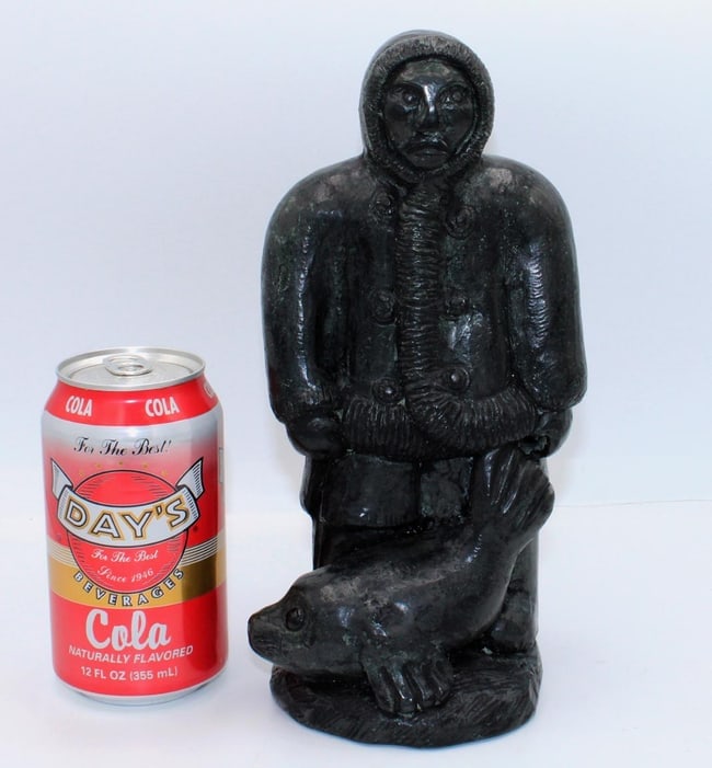 A Native Alaskan stone carving of a man and a seal. - 8