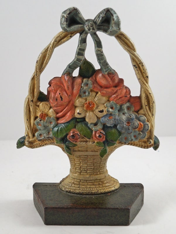 Mixed Flowers in Basket Cast Iron Judd Doorstop: Title: Mixed Flowers in Basket Cast Iron Judd Doorstop Dimension: 8 3/8" tall x 6" wide. Date: Circa 1920's. Additional Information: An Antique Doorstop featuring a striking grouping of brightly