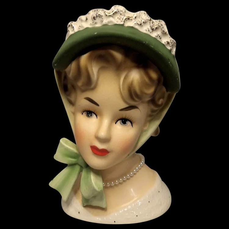 Brinns TV 726 7 1/4" Lady Head Vase Green Hat and Bow- "Pearl Necklace": This Brinns TV 726 7 1/4" Lady Head Vase Green Hat and Bow- "Pearl Necklace" is in very good to excellent condition. It does have some eye paint missing and has crazing under magnification. If it was
