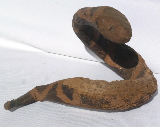 A carved and painted folk art snake: This is a carved and painted folk art snake. It has good decoration and is coiled as if to strike. There is a wonderful little carved piece nailed to the bottom to make it stand up higher. The snake