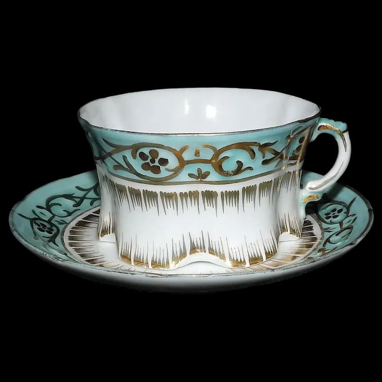 Antique Gold Gilded White & Blue Porcelain Cup and Saucer: This Antique Gold Gilded White& Blue Porcelain Cup and Saucer is a stunning example of the Victorian era. It is in excellent condition. No loss of color, chips, flea bites, but does have some minor
