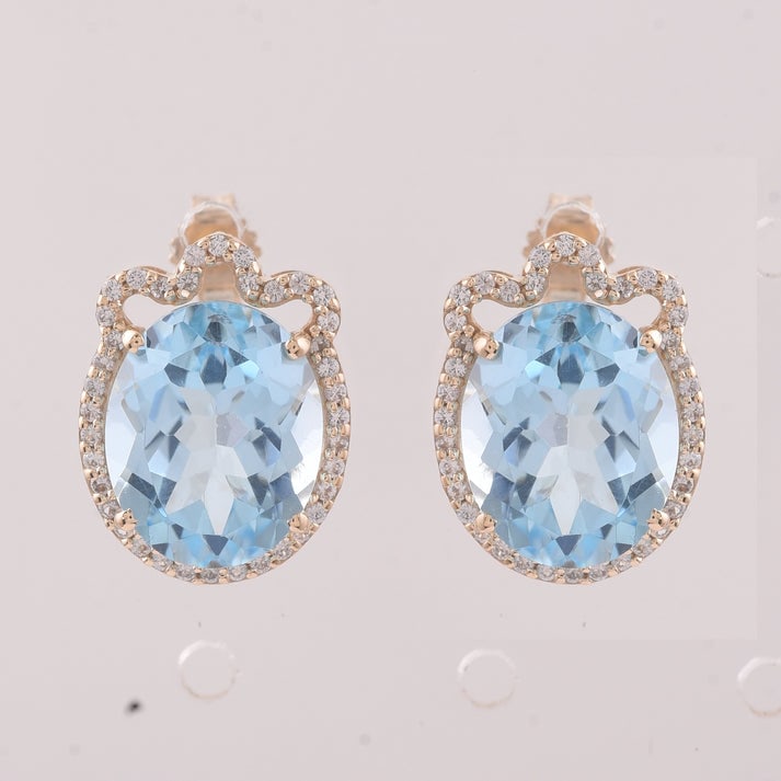 9.24 Ct Oval Blue Topaz 9K Gold Earrings: 9.24 Total Carat Blue Topaz 9K Gold Earrings Specifications: Total Weight 3.686 g Center Gemstone Blue Topaz Gemstone Carat Weight 8.94 Carats Gemstone Measurements 11X9 mm Additional Gemstones White 