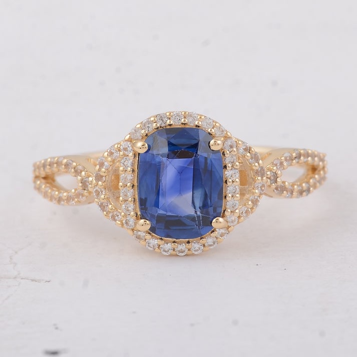 1.69 Ct Cushion Sapphire 9K Gold Ring: 1.69 Total Carat Sapphire 9K Gold Ring Specifications: Total Weight 1.95 g Center Gemstone Sapphire Gemstone Carat Weight 1.39 Carats Gemstone Measurements 7.50X5.80X3.30 mm Additional Gemstones White